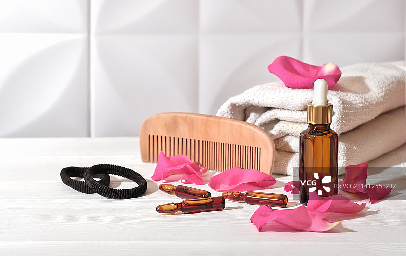 防脱发安瓿和精华液滴管瓶，护发和头皮护理产品，旁边放着一条毛巾图片素材