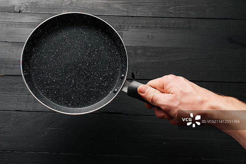 黑色木纹背景上的空锅图片素材