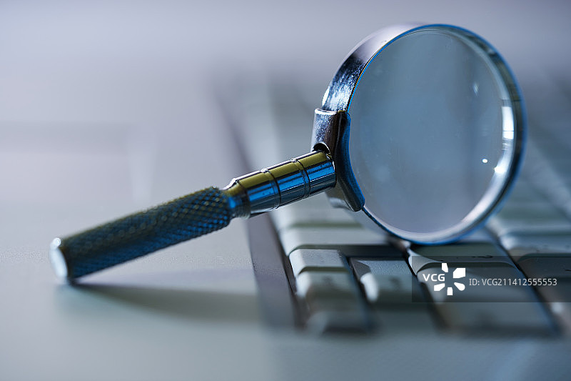 电脑键盘上的放大镜特写，马来西亚图片素材