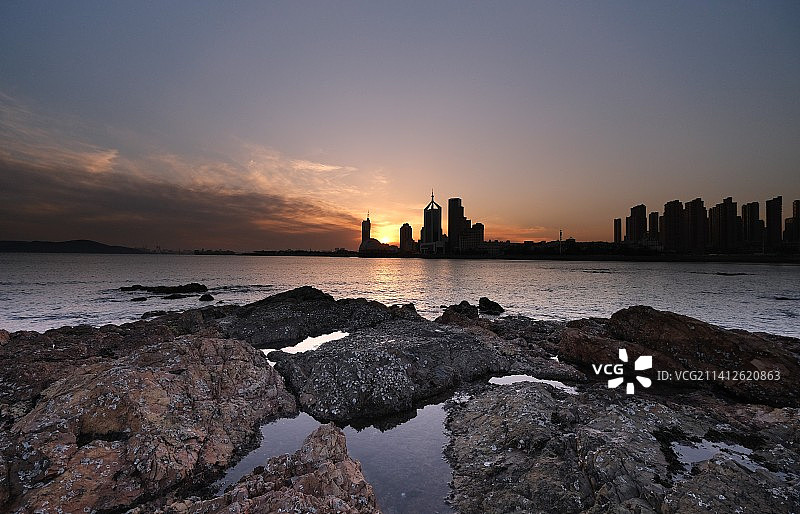 前海黄昏时 0℃，栈桥西侧的礁石上，望日落八大峡海滨。图片素材