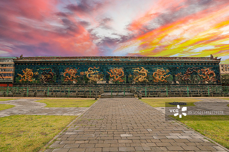 日落晚霞映照下的山西省大同市九龙壁（是明太祖朱元璋第十三子朱桂代王府邸前照壁）图片素材