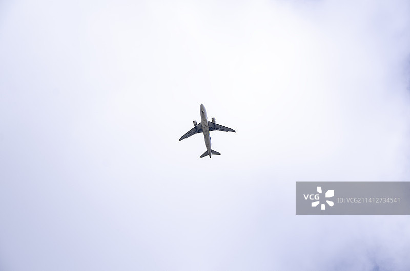 飞机飞过蓝天白云间图片素材