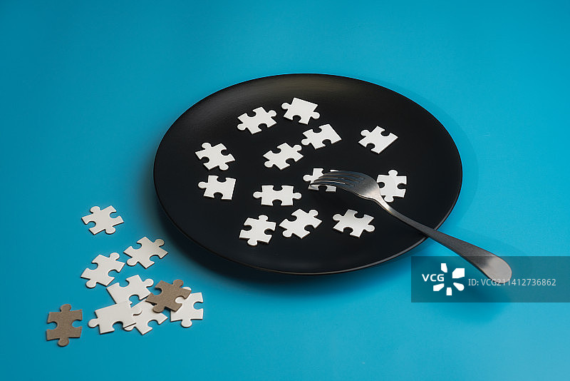 放在黑色盘子中的拼图模块微缩静物照图片素材