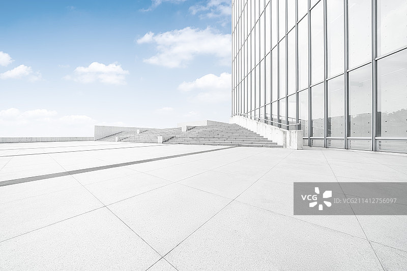 晴朗的天气下，现代办公大楼和干净宽阔的广场图片素材