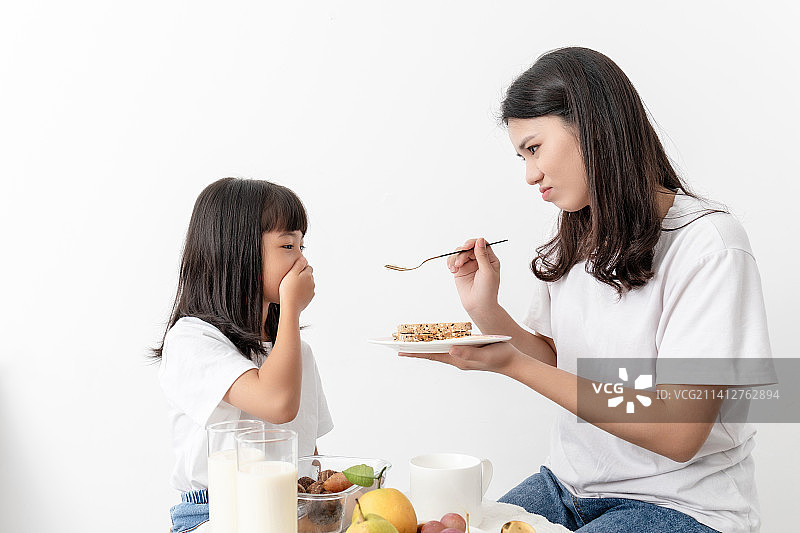 一名中国妈妈在喂女儿吃早餐图片素材