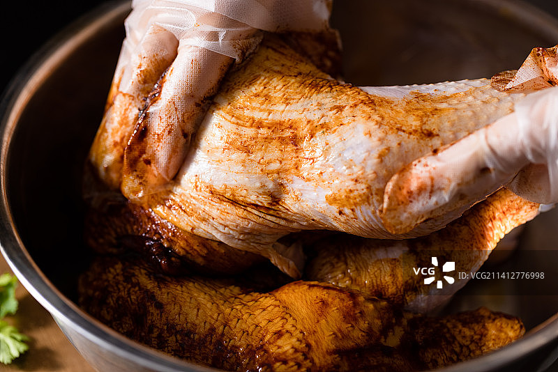 厨师的一双手在新鲜鸡腿上涂抹酱汁腌制图片素材