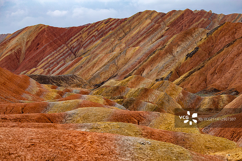 多云的天气，甘肃张掖，山间绚丽的七彩丹霞地貌。图片素材