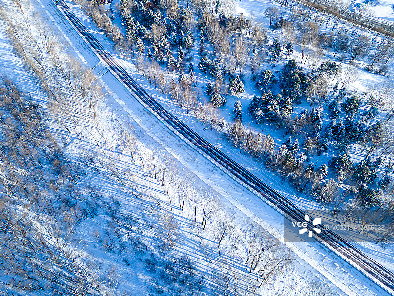 雪后树林间的公路鸟瞰图片素材