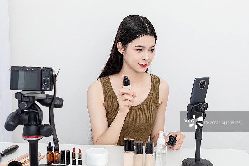 室内一名漂亮的亚洲美女在做美妆直播图片素材