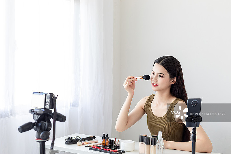 室内一名漂亮的亚洲美女在做美妆直播图片素材