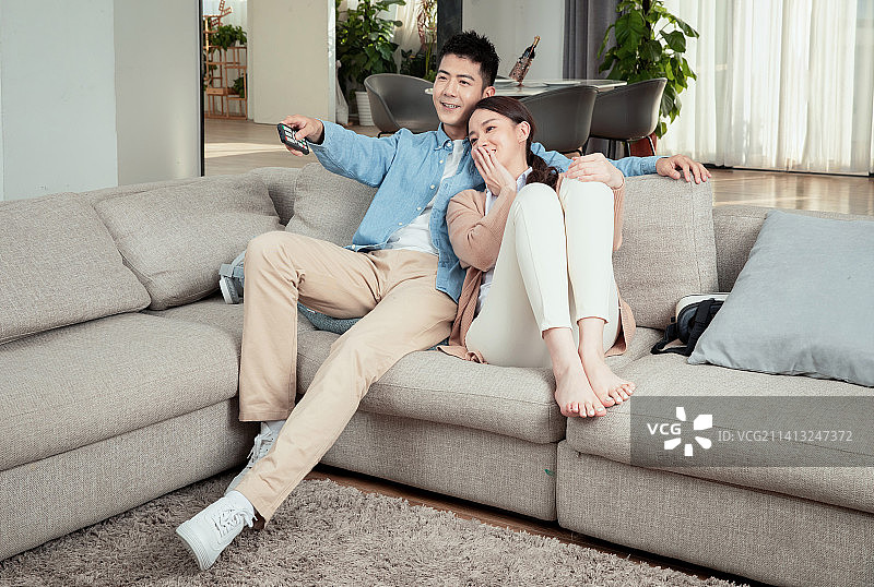 坐在客厅看电视的青年男女图片素材