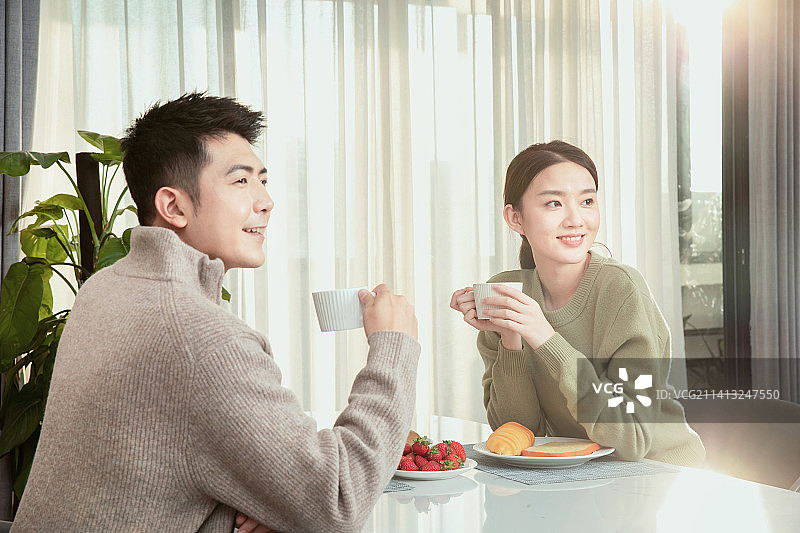 面对面坐在餐桌前的青年男女图片素材