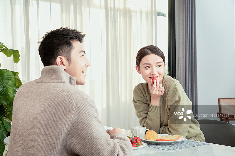 面对面坐在餐桌前的青年男女图片素材