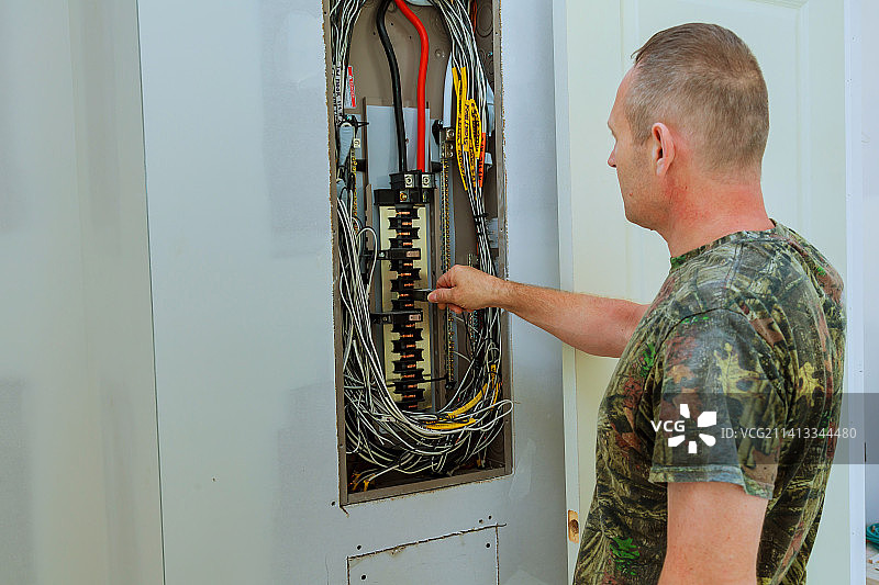 专业电工在电气屏蔽中安装组件图片素材