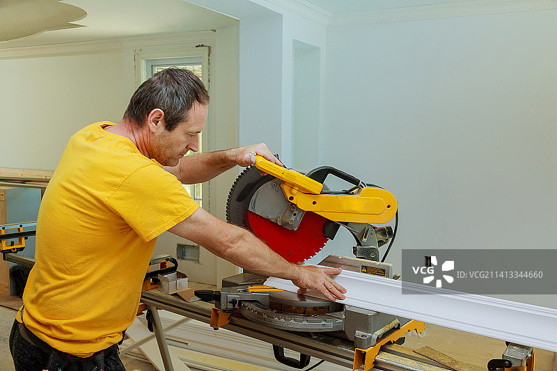 装修工人用圆锯切割石膏线条图片素材