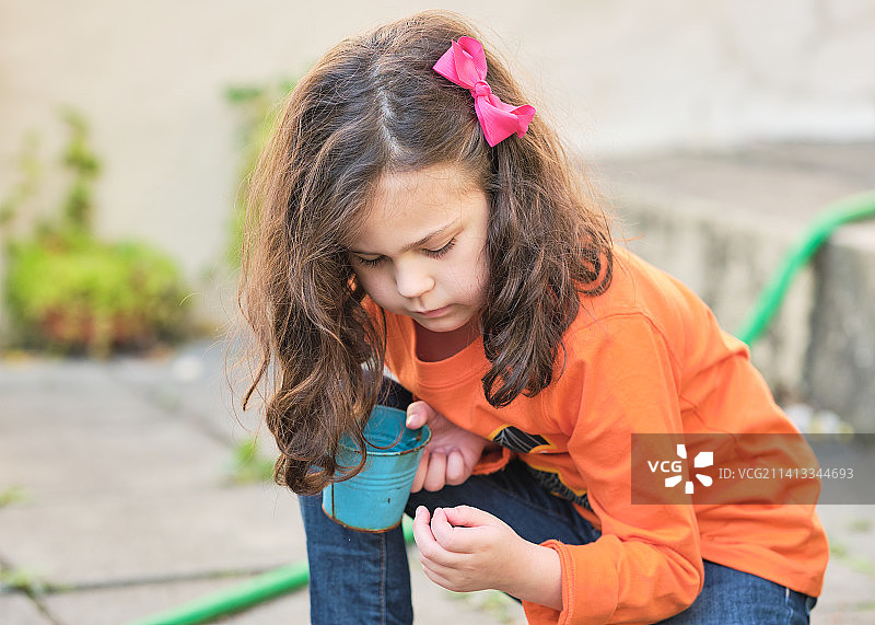 小女孩在后院玩植物和水桶，美国纽约图片素材