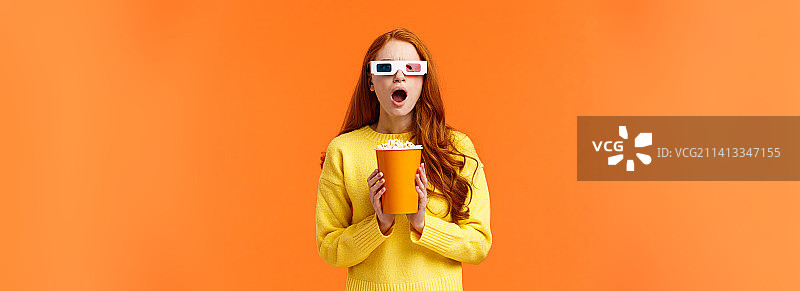 红发女子震惊地看着屏幕上的激烈战斗图片素材