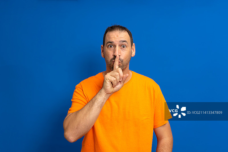 留着胡子的拉丁裔男人穿着橙色休闲T恤图片素材