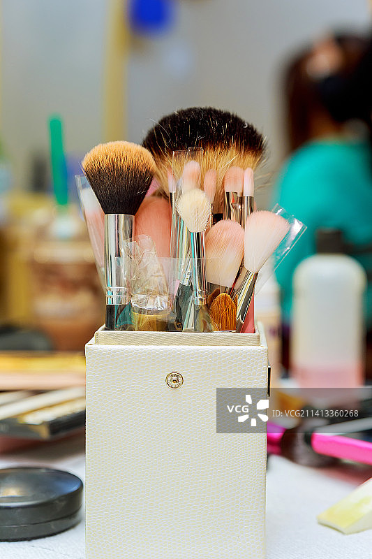 桌子上容器中的化妆刷特写图片素材