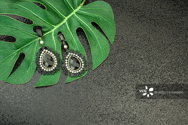 带有绿色树叶和项链的黑色背景，英国图片素材