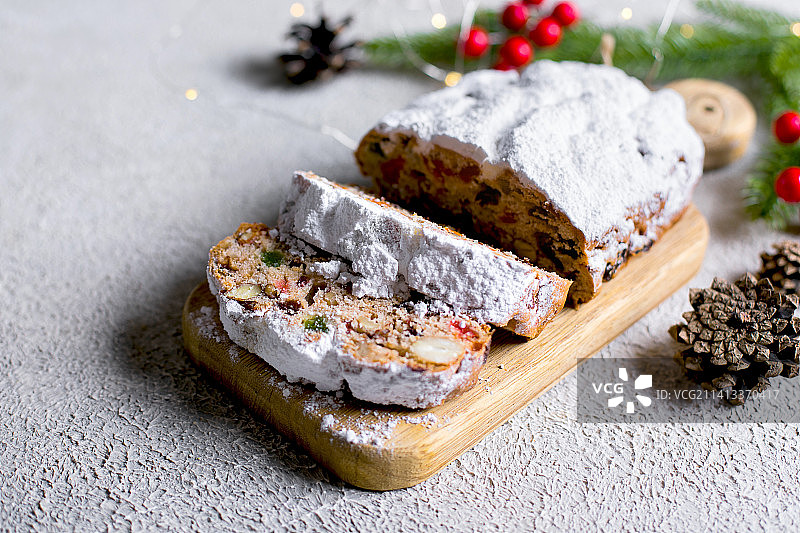 浅色混凝土背景木制托盘上的圣诞史多伦蛋糕，传统圣诞糕点图片素材