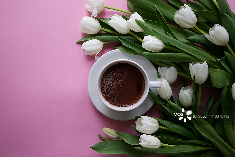 粉色背景上的咖啡与白色郁金香图片素材