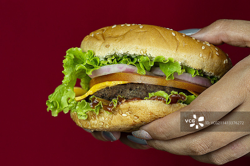 手持汉堡，黑色背景，多米尼加共和国图片素材