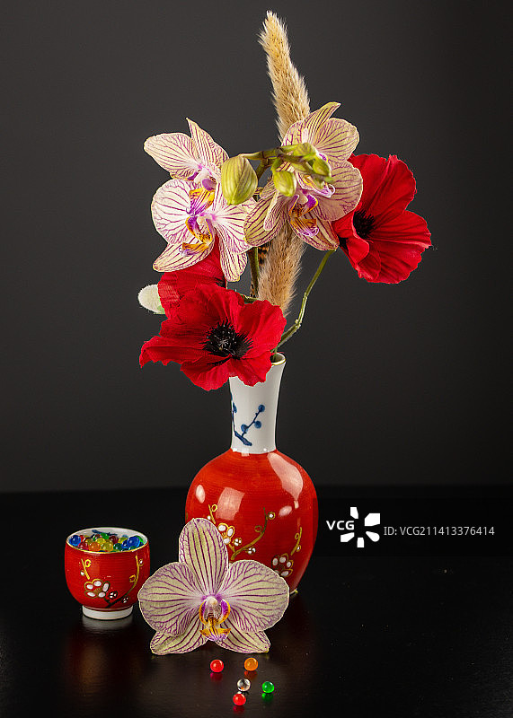 黑色背景下，花瓶中的花卉特写图片素材