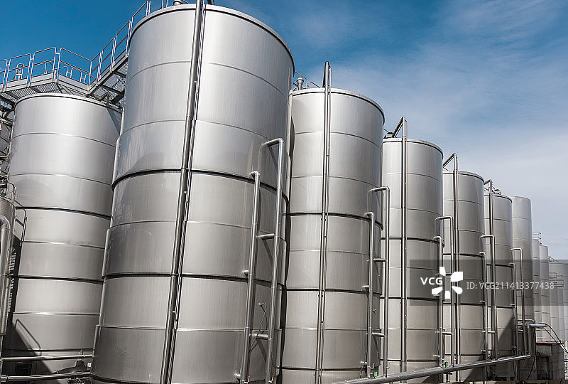 现代化酿酒厂的葡萄酒发酵钢罐，意大利布林迪西的大型啤酒厂大麦或啤酒筒仓图片素材