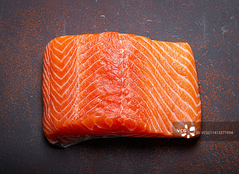 深棕色原木上的新鲜挪威生三文鱼片图片素材