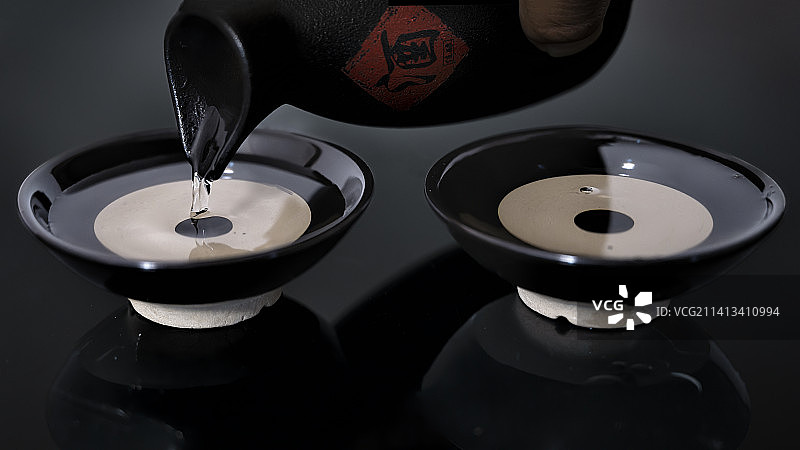 在黑色背景上倒白酒的特写镜头图片素材