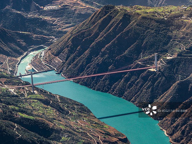 云南丽江的冬日，金沙江蜿蜒穿行峡谷，桥梁飞跨蓝色江水图片素材