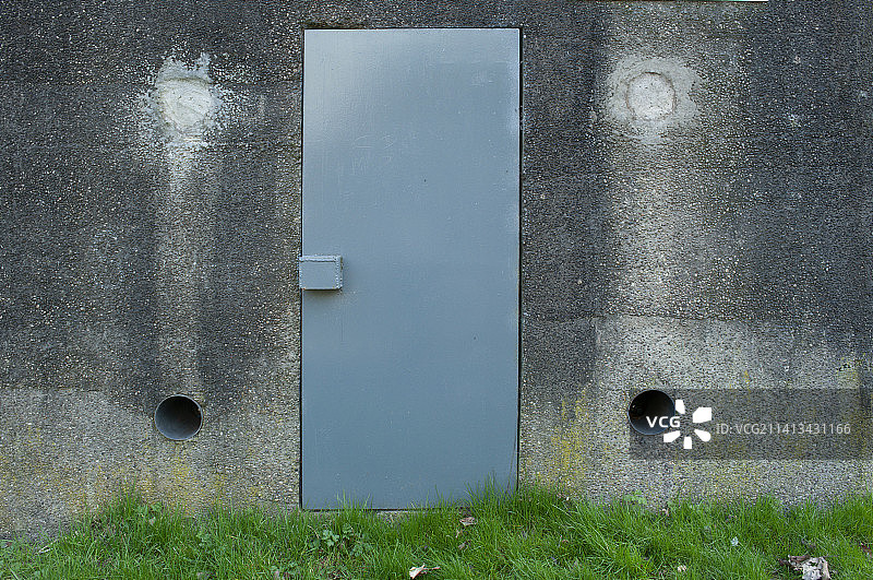 厚重混凝土墙上的金属门图片素材