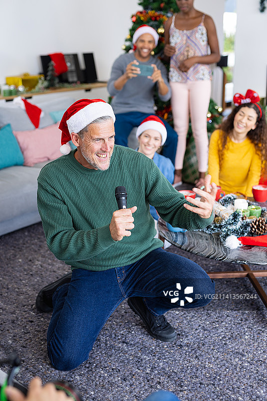 高加索男人和朋友一起唱卡拉OK庆祝圣诞节竖版图图片素材