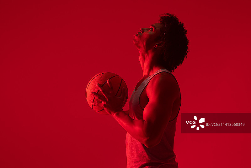 霓虹灯背景下的混血篮球运动员图片素材