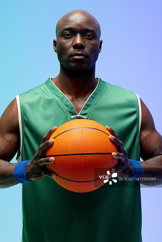 非裔美国篮球运动员在绿色到蓝色背景下的肖像图片素材