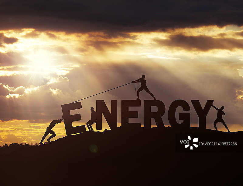 一群青年人将字母ENERGY拖上山顶剪影图片素材