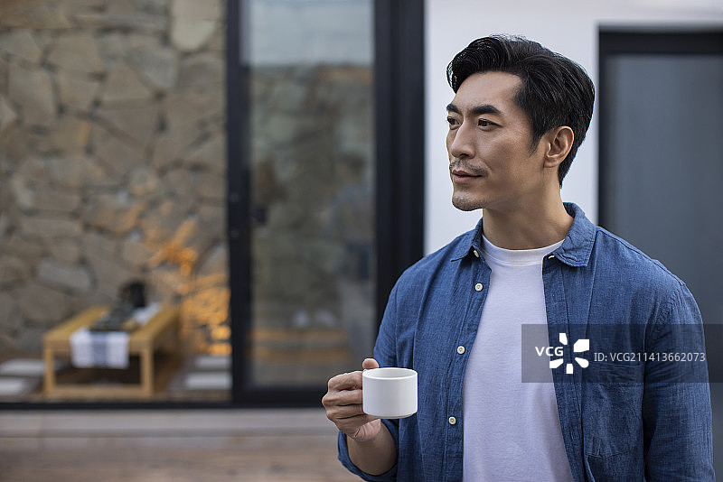 中年男子在院子里喝咖啡图片素材