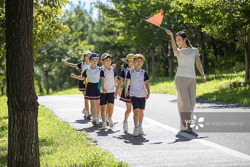 快乐的老师带领小学生春游图片素材