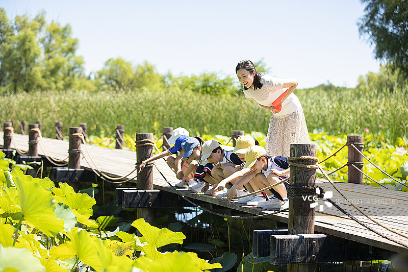 快乐的老师带领小学生春游图片素材