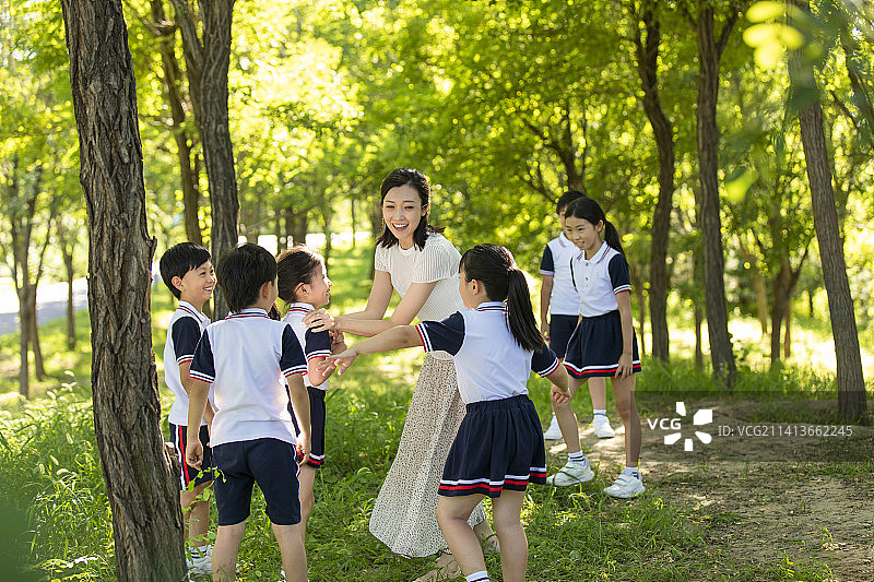 快乐的老师带领小学生春游图片素材