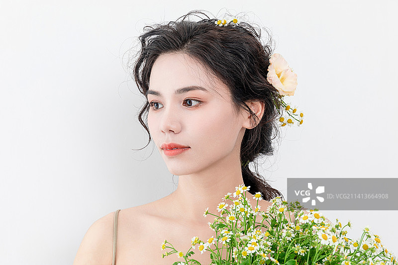 鲜花美妆造型亚洲美女手捧着一束洋甘菊图片素材