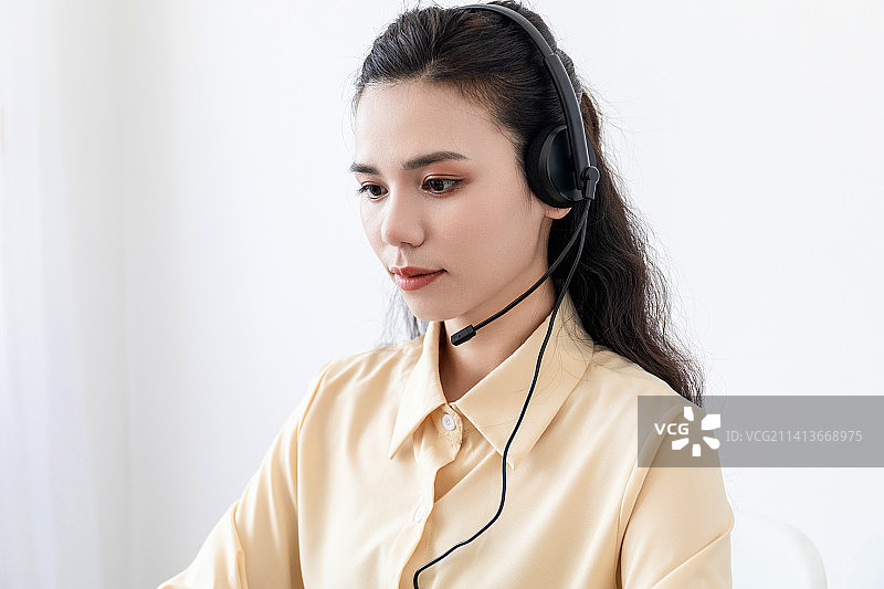 室内带着耳麦的亚洲商务女士女客服女销售图片素材
