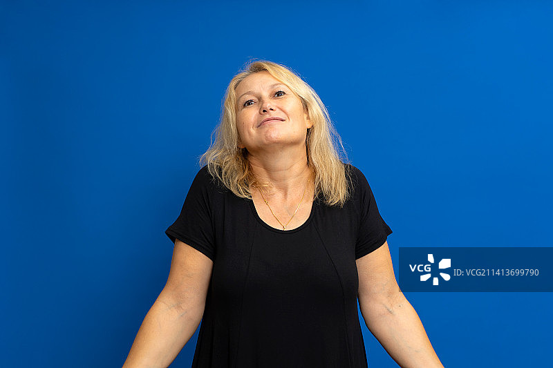 可爱的女人耸肩，困惑不确定的肖像照图片素材