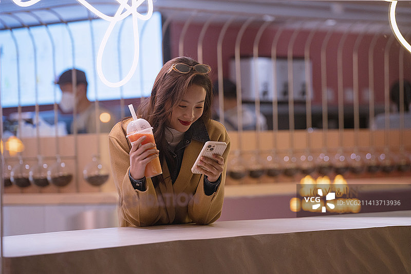年轻女人在奶茶店等待图片素材