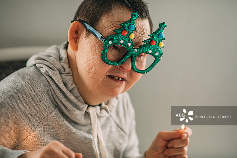 患有唐氏综合征的老年妇女戴着有趣的圣诞眼镜图片素材