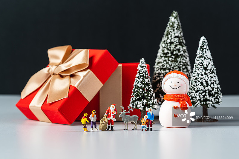 圣诞节平安夜圣诞老人在雪地里给孩子们送礼物创意微缩景观图片素材
