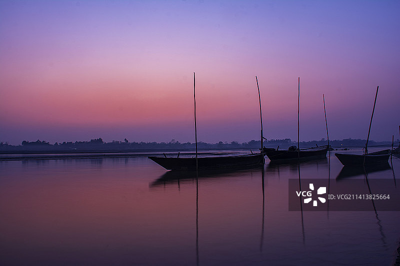 印度西孟加拉邦库奇比哈尔邦日落时湖中帆船的轮廓图片素材