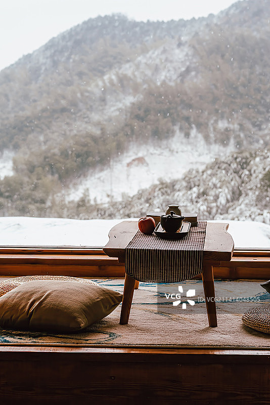 民宿室内的沙发茶几和窗外的雪景图片素材