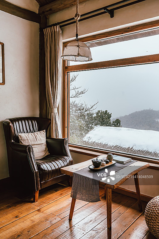 民宿室内的沙发茶几和窗外的雪景图片素材
